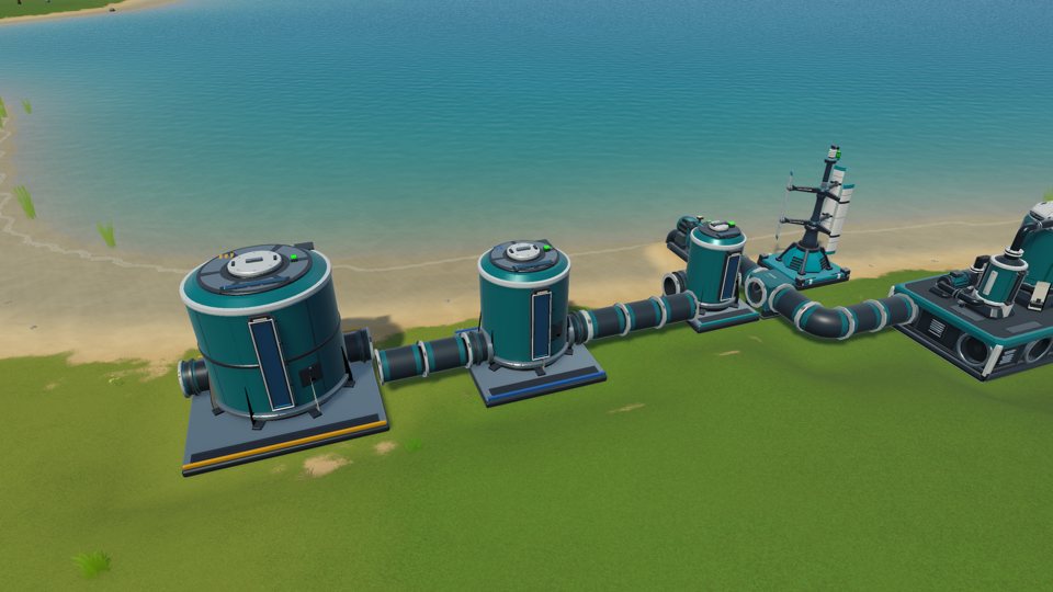 A water pump on the shore piping into tanks and a chemical plant
